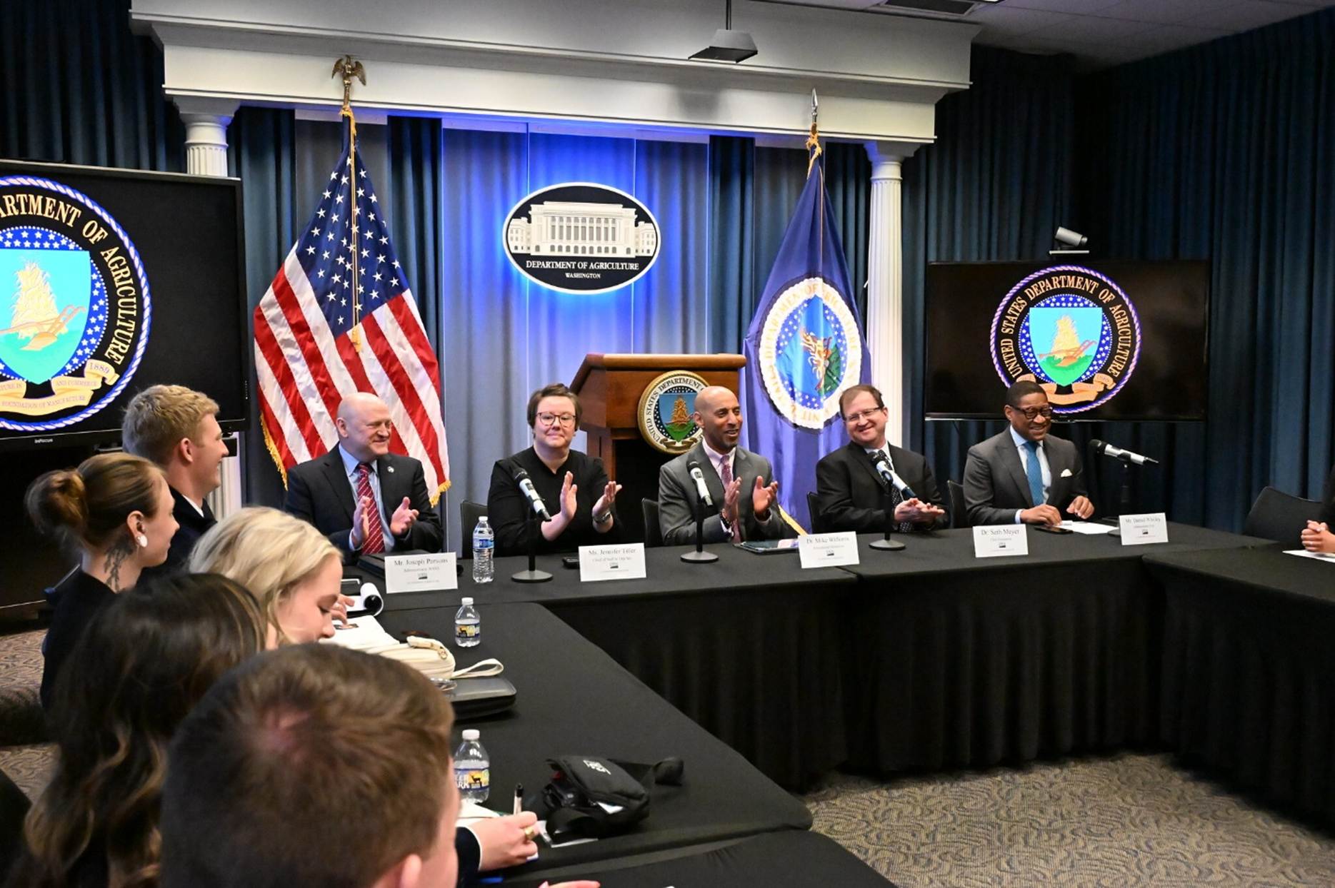 A group of people sitting at a table

AI-generated content may be incorrect.