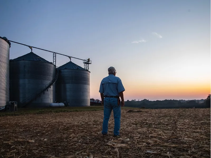 Farmer with grain bins USDA.jpg