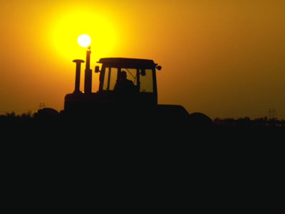A tractor drives into the sunset