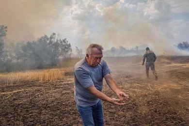 farmer next to fires in Ukraine wheat field .jpg